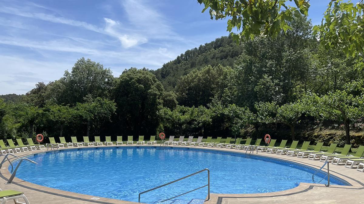 Piscina rodeada de naturaleza en el camping.