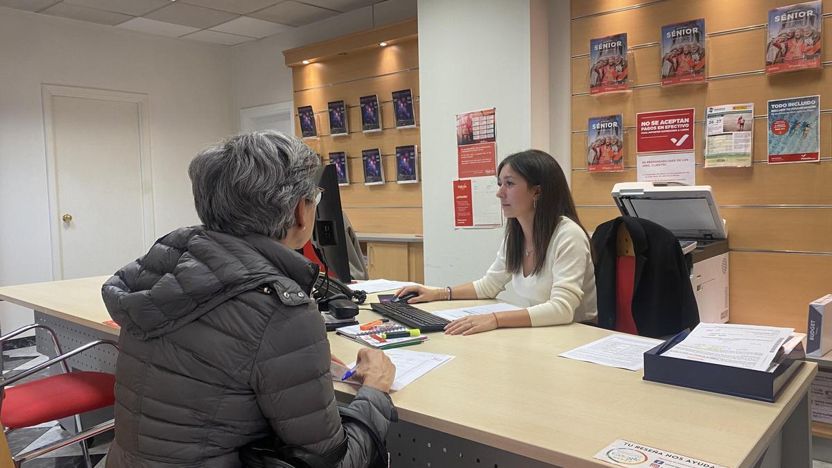 Una mujer en solicita información acerca de los viajes del Imserso en una agencia de viajes de Zaragoza.