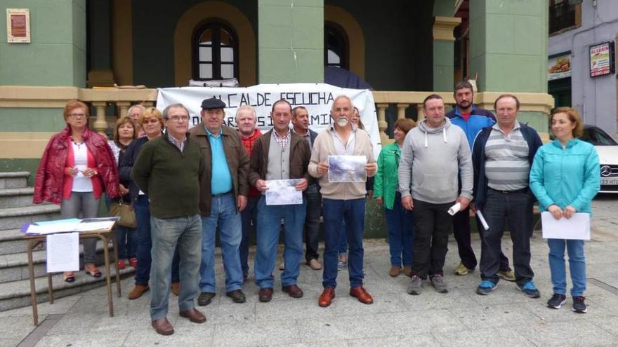 Vecinos de Besapié, ayer, delante del Ayuntamiento de Tineo, con las pancartas que expresan sus reivindicaciones y la mesa para la recogida de firmas.