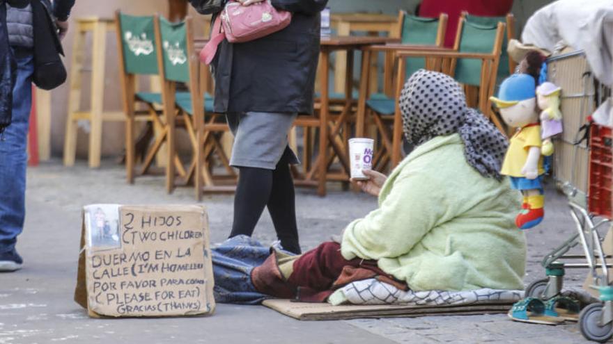 Una mujer pidiendo en una calle de València.