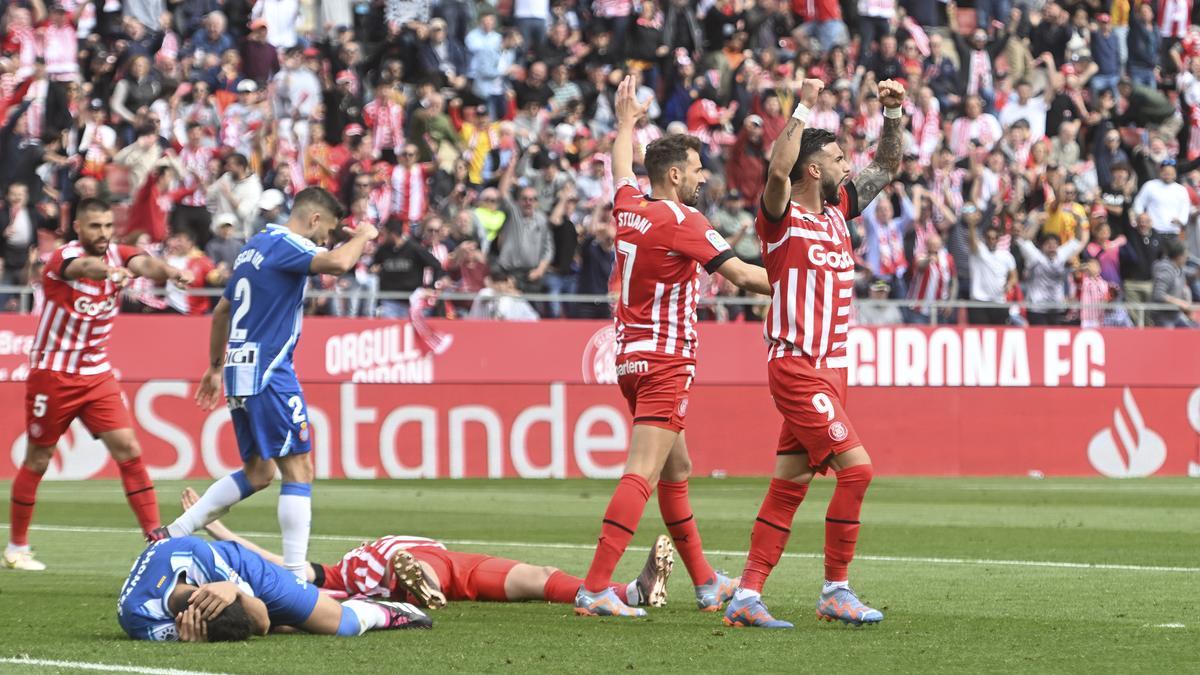 Jugadores de ambos equipos reaccionando de forma diferente ante el penalti señalado durante el partido de liga entre el Girona CF y el RCD Espanyol.