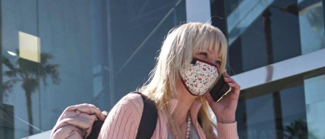 Una turista espera fuera del Aeropuerto Tenerife Sur.