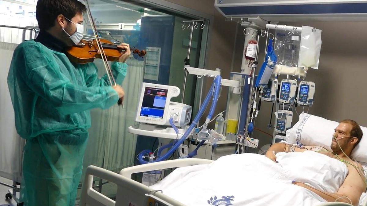 El violinista Paco Montalvo toca en directo para un paciente de la UCI del Hospital San Juan de Dios de Córdoba.