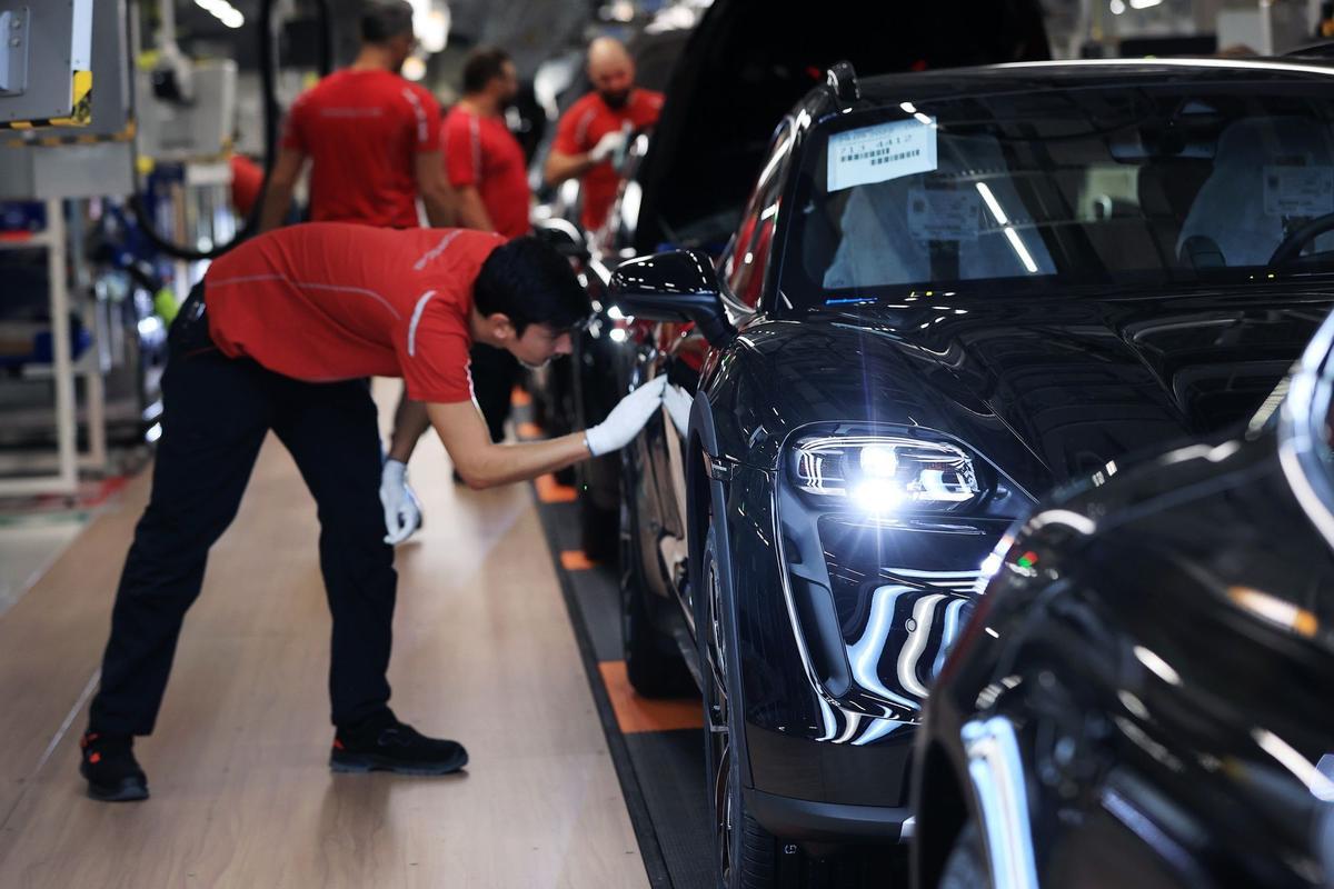 Los empleados trabajan en las carrocerías de los automóviles de lujo Porsche Taycan totalmente eléctricos en la línea de producción de la fábrica de Porsche AG en Stuttgart, Alemania.