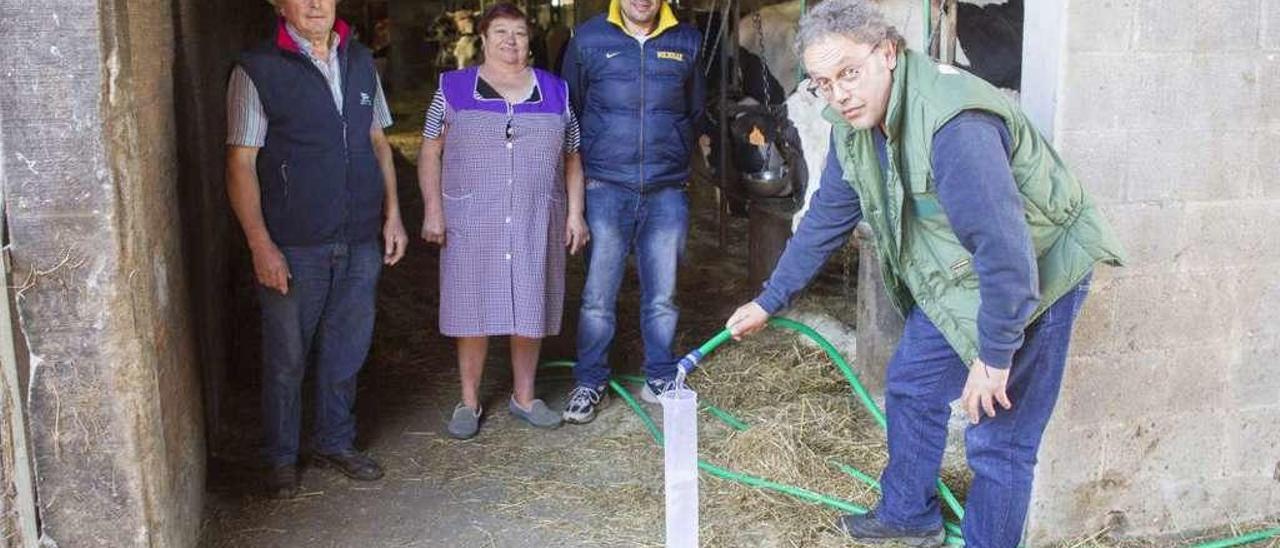 El técnico Fernando Leis echa agua en una probeta en Ganadería Flora, en Vilatuxe, bajo la mirada de los dueños . // Bernabé/Ana Agra