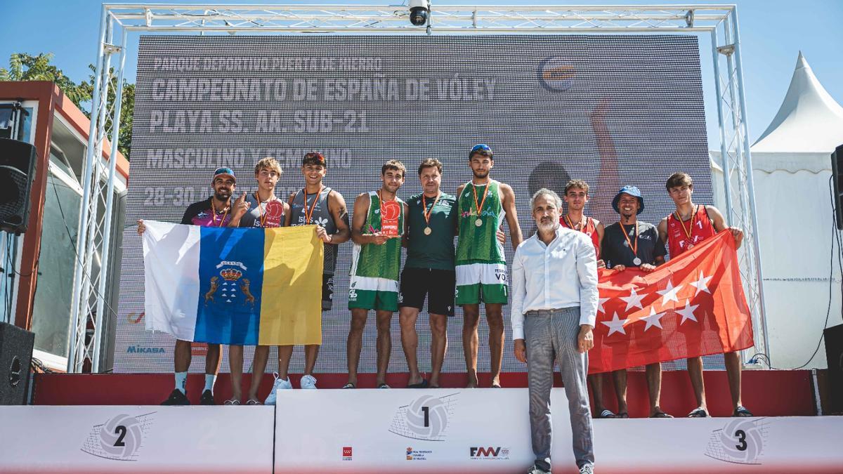 Kako Hernández, el entrenador canario, junto a sus pupilos Leo Koeppen y Efrén Morales, con la bandera canaria en el podio