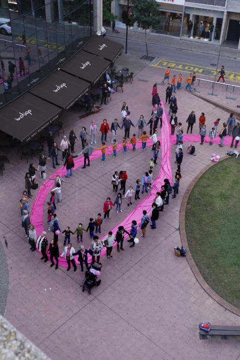 Un centenar de persones van crear el llaç rosa gegant de l''Oncolliga a la ciutat de Girona