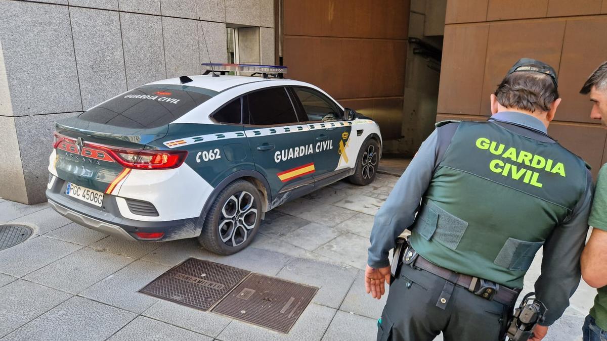 Uno de los detenidos accediendo en un coche de la Guardia Civil al Palacio de Justicia de Llamaquique.