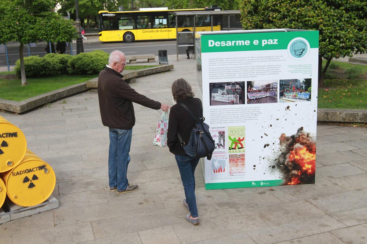 Un par de vecinos se fijan en los paneles expositivos.