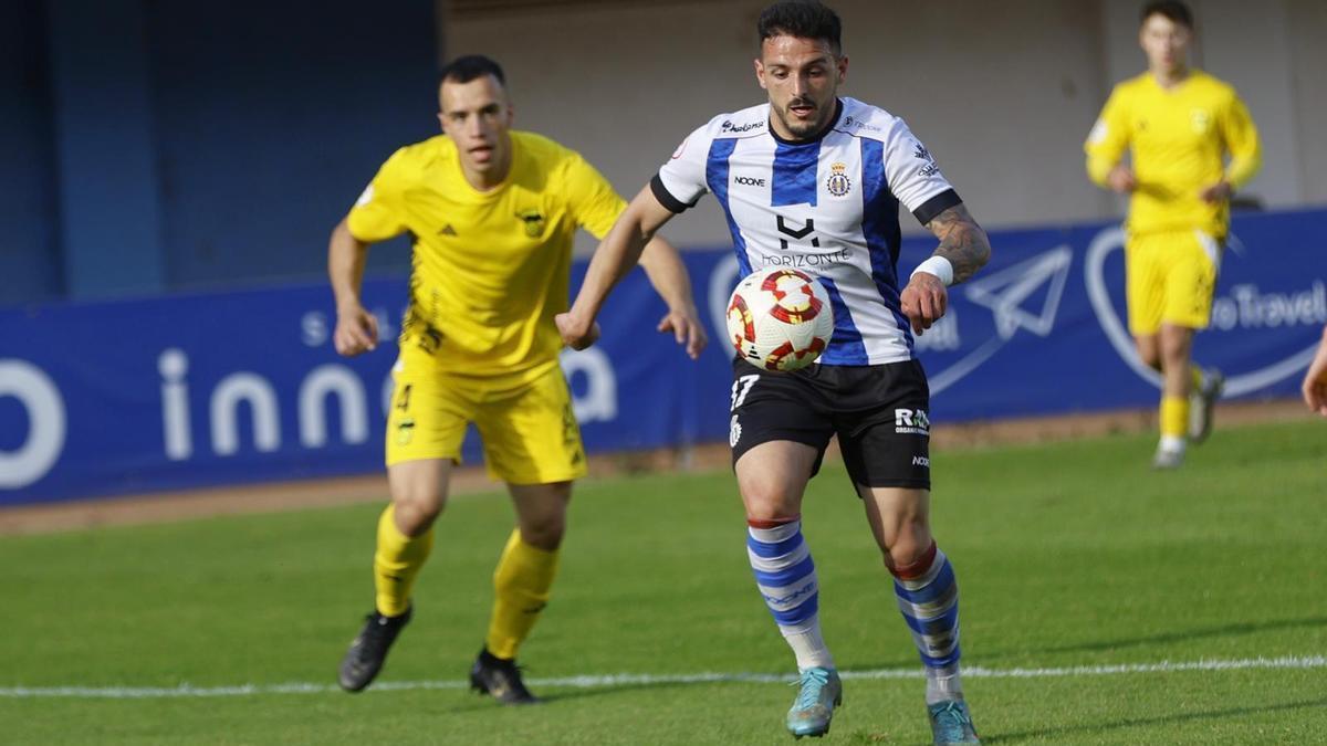 Callís conduce el balón con Keko Hevia detrás