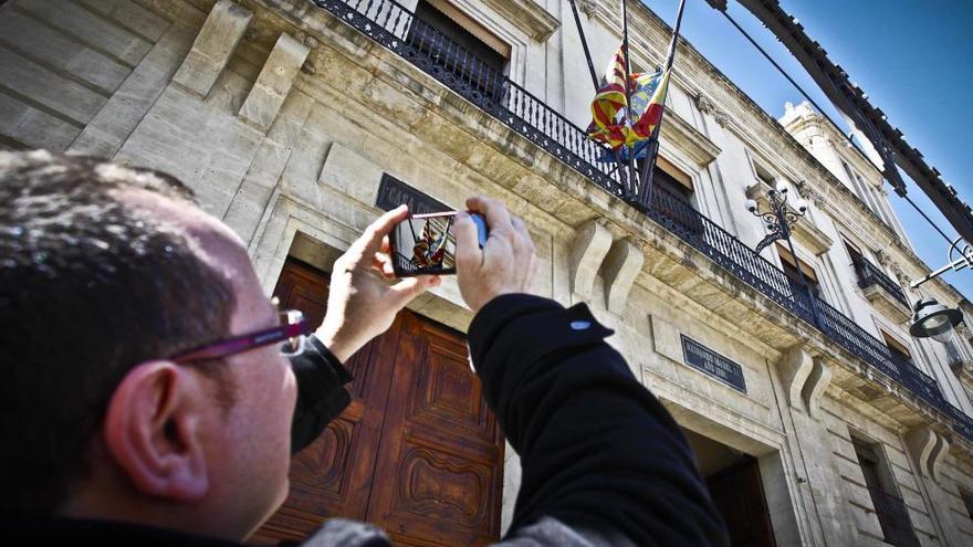 David Abad, portavoz de Compromís, fotografía las banderas a media asta en el Ayuntamiento