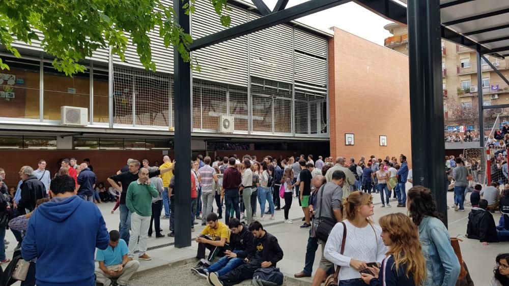 La gent espera l'arribada de la policia a l'escola el Pla.