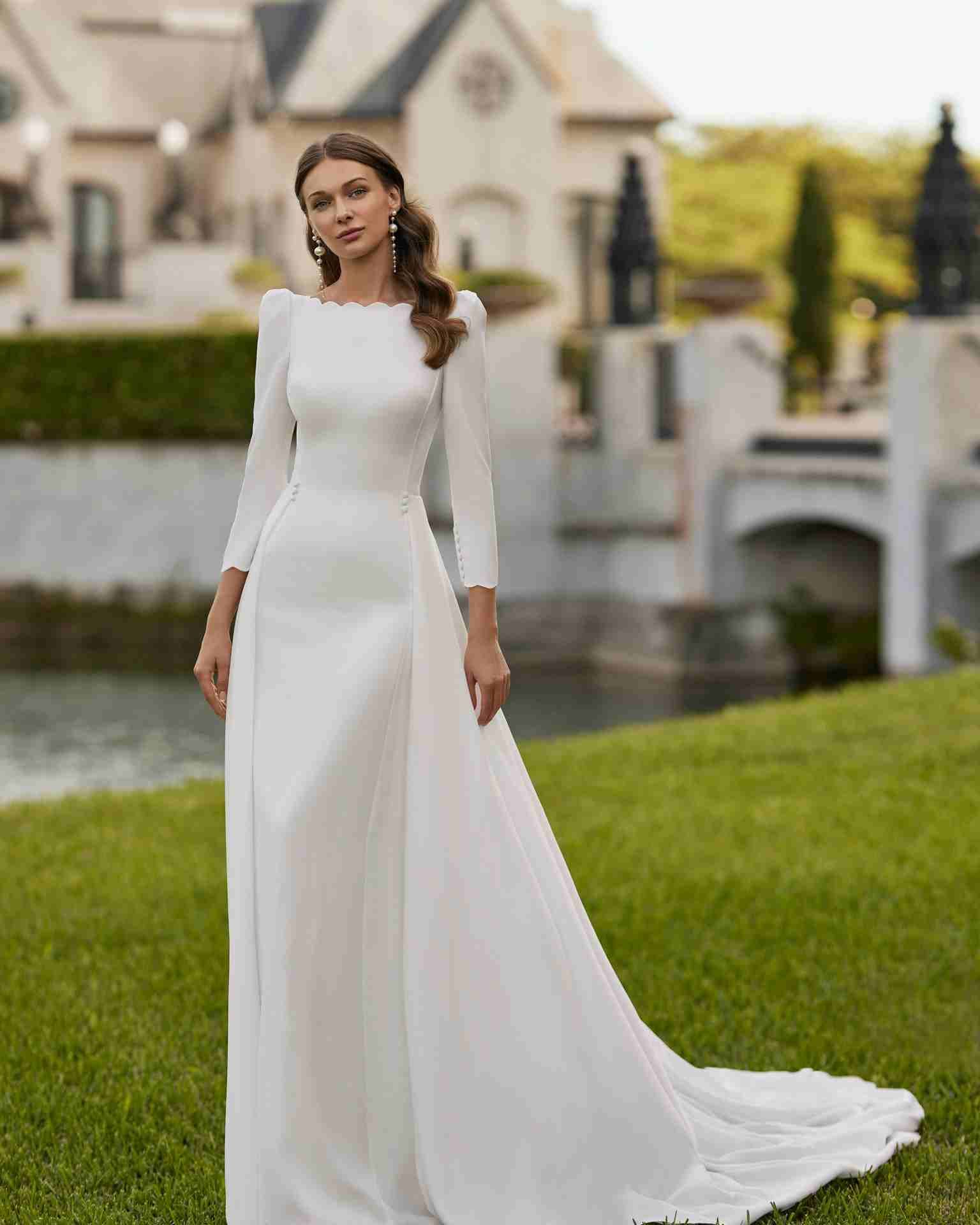 Vestido de novia con escote barco, espalda en V, manga francesa y sobrefalda