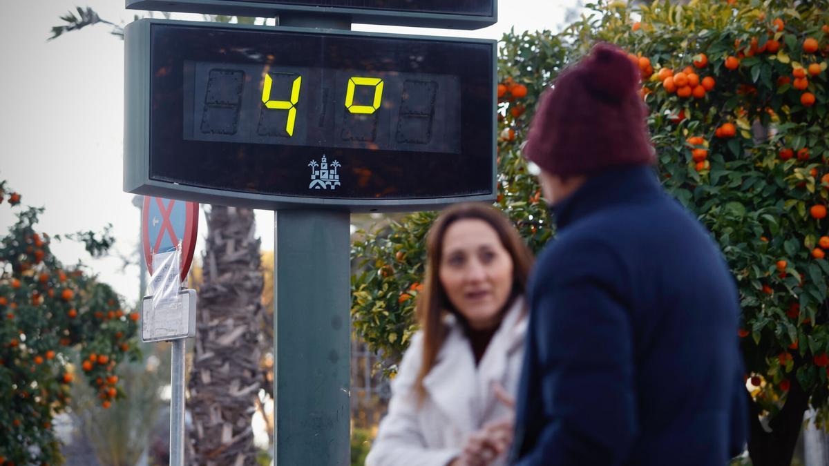 Dos mujeres caminan ante un termómetro que marca 4 grados.