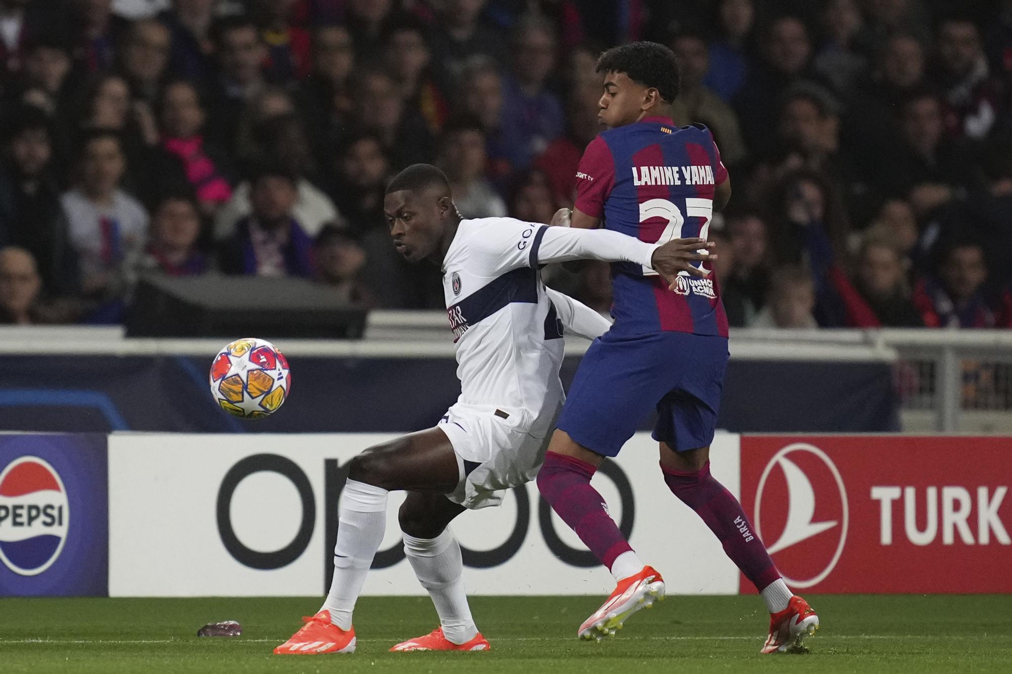 PSG's Nuno Mendes, left, is challenged by Barcelona's Lamine Jamal during the Champions League quarterfinal second leg soccer match between Barcelona and Paris Saint-Germain at the Olimpic Lluis Companys stadium in Barcelona, Spain, Tuesday, April 16, 2024. (AP Photo/Emilio Morenatti)