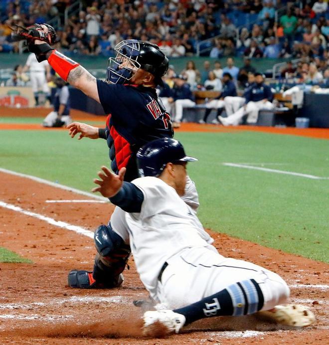 Christian Vázquez # 7 de los Medias Rojas de Boston no puede detener a tiempo a Avisail Garcia # 24 de los Rays de Tampa Bay anotó durante la parte inferior de la sexta entrada de su juego en el Tropicana Field.