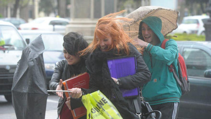 Varios viandantes luchan contra el viento, ayer, en A Coruña. / Víctor Echave