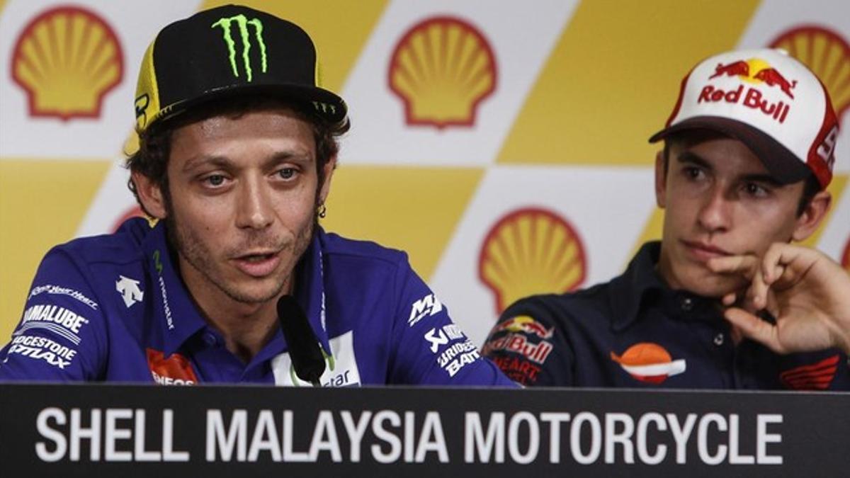 Valentino Rossi explica sus sensaciones antes del Gran Premio de Malasia, bajo la atenta mirada de Marc Márquez