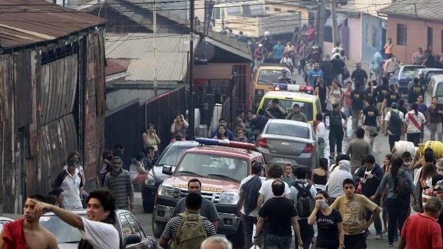 Vecinos de Valparaíso, aturdidos en la calle por el desastre.  // Efe