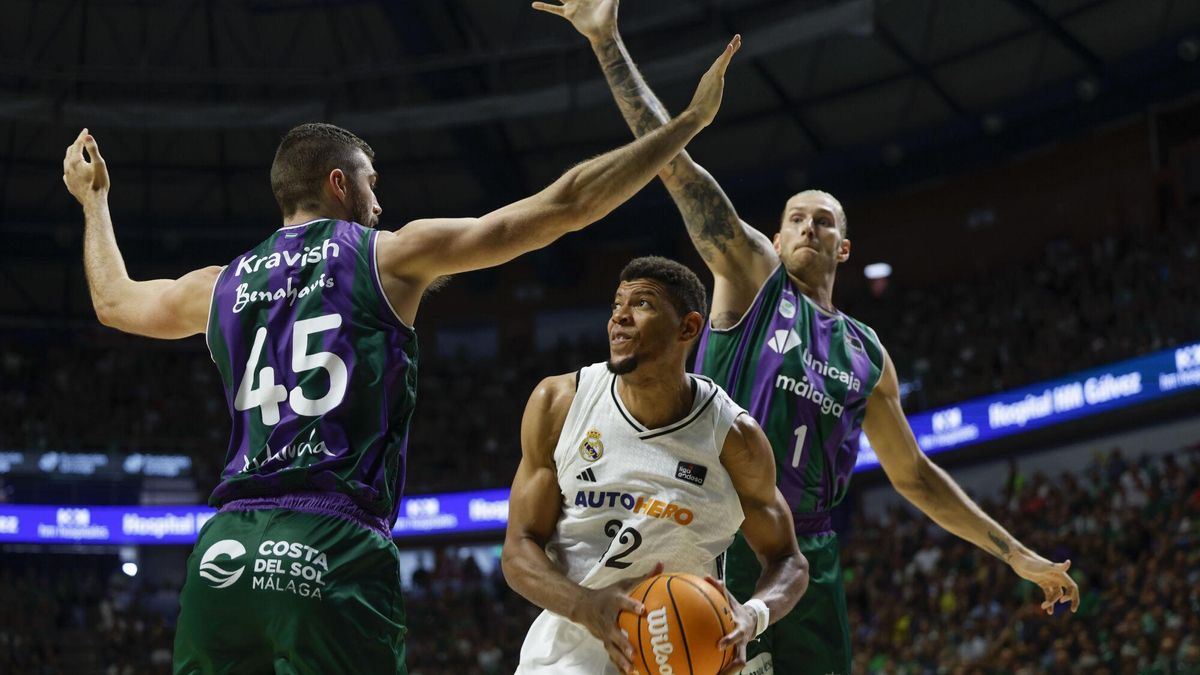 El pívot de Cabo Verde del Real Madrid Edy Tavares (c) en acción ante la defensa de David Kravish (i) y Dylan Osetkowski del Unicaja este domingo, durante el tercer partido de semifinales de la Liga Endesa de Baloncesto, entre el Unicaja y el Real Madrid, en el Palacio de Deportes José María Martín Carpena de Málaga (Andalucía). EFE/ Jorge Zapata