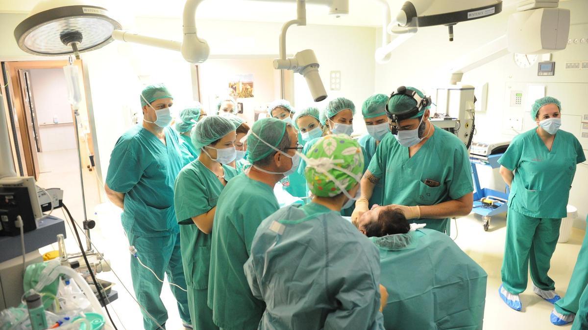 Alumnos en prácticas asisten a una intervención en el hospital Reina Sofía.