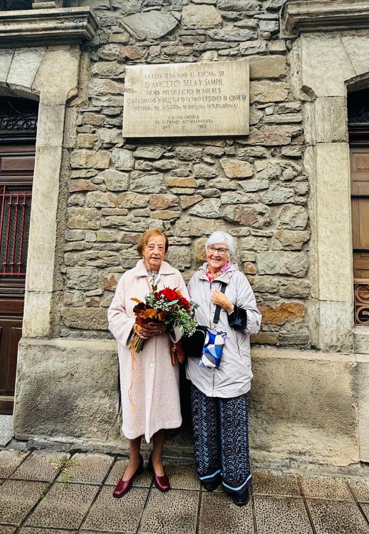 Dos de las familiares de Aniceto Sela, bajo la placa que lo recuerda.