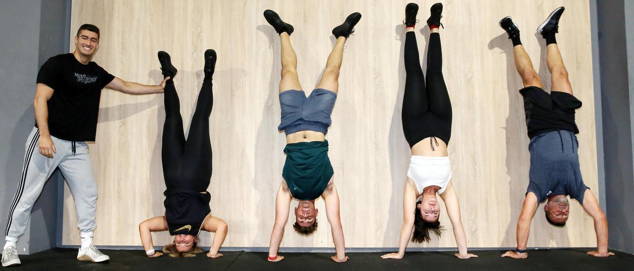 Rosa, Samuel, Naiara y Alfonso, haciendo el pino en una clase de 'crossfit' junto con su entrenador Pedro Crespo.