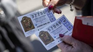 Unamujer muestras sus décimos para la Lotería del Niño de 2023.